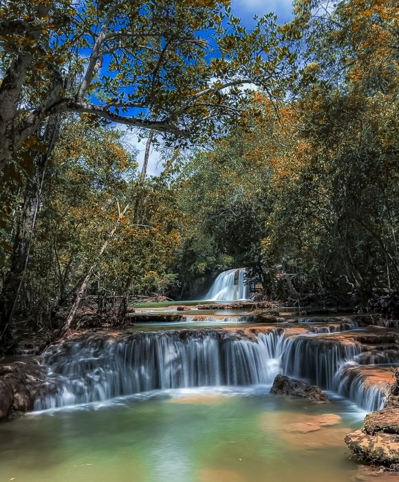 Admire the beauty of the Água Doce Waterfall in Estância Mimosa (Bonito/MS), where the crystal clear waters glide amidst the lush vegetation.